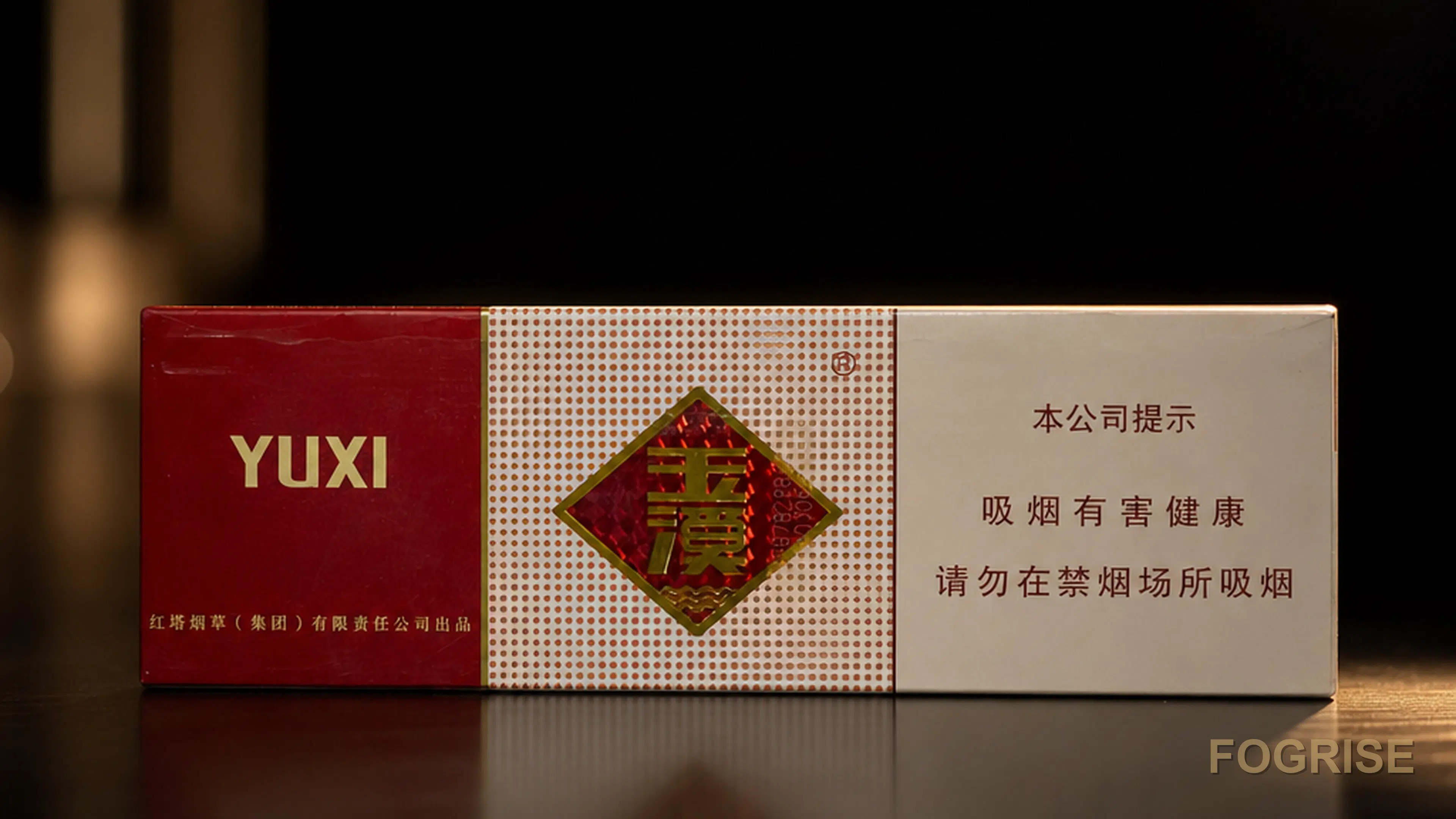 A real Yuxi (玉溪) cigarette pack, A single authentic Yuxi 玉溪 cigarette pack standing on a deep charcoal #1A1A1C surface with