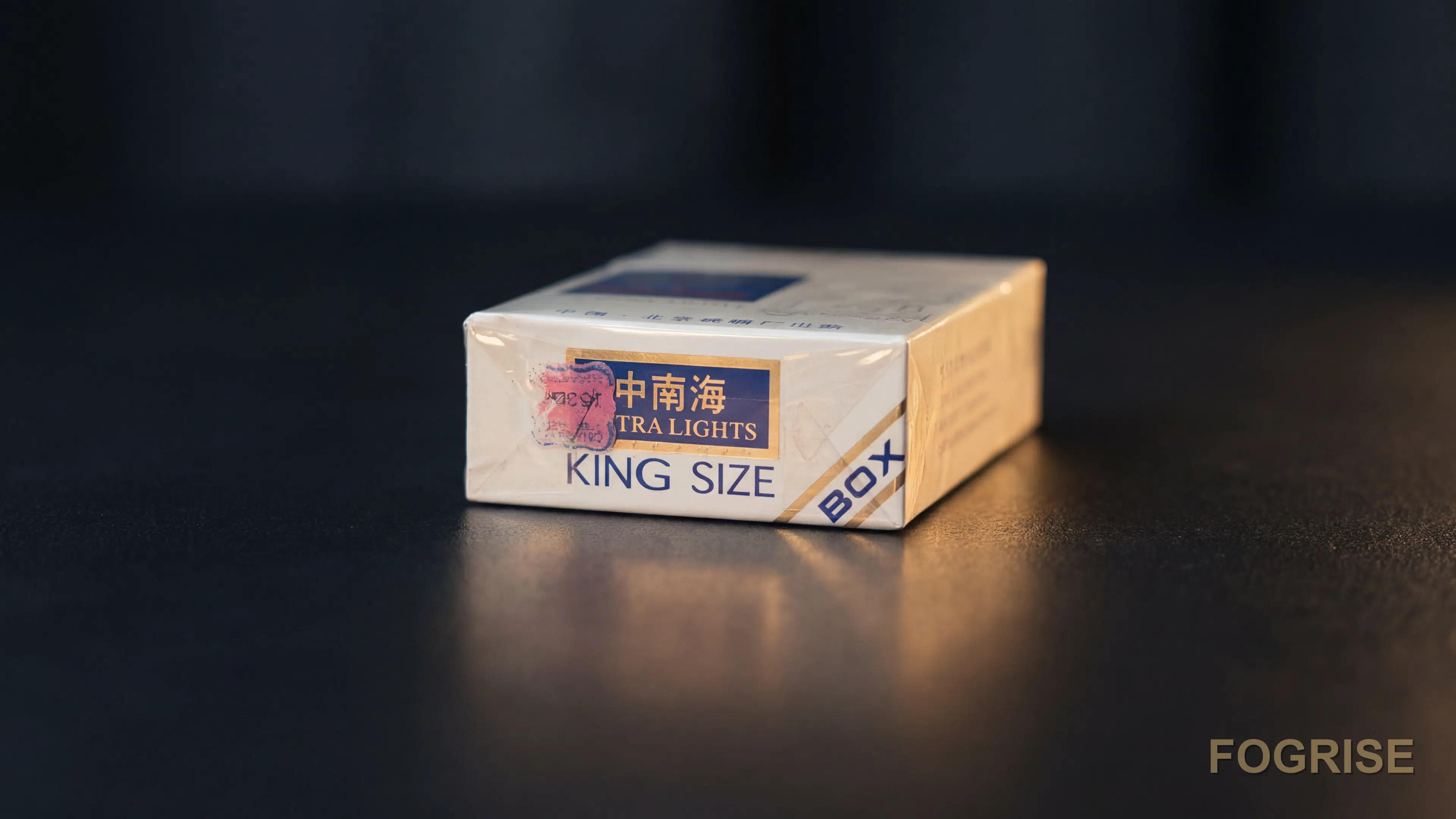 A real Zhongnanhai (中南海) cigarette pack, A single authentic Zhongnanhai 中南海 pack on a dark tabletop in a soft customs/inspec
