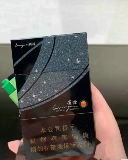 Guiyan Kuayue Slim cigarette packaging, front of a black star-patterned pack held in one hand
