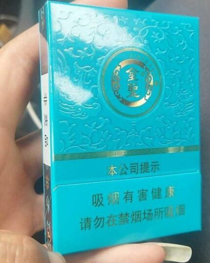 Jinsheng Qingci Mid cigarette packaging, close-up of the turquoise pack held in one hand
