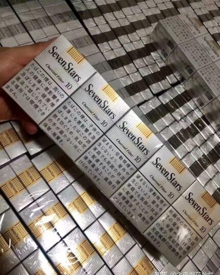 Seven Stars Charcoal cigarette packaging, two wrapped cartons held above stacked inventory