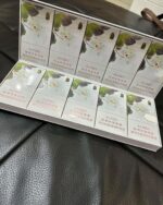 Taishan Jasmine Slim cigarette packaging, packs arranged in an open carton on a black leather seat