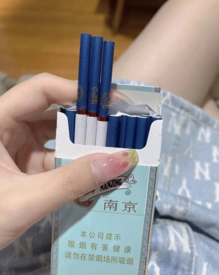 Nanjing Xuanhemen Slim cigarette packaging, opened pale blue pack held with several cigarettes visible