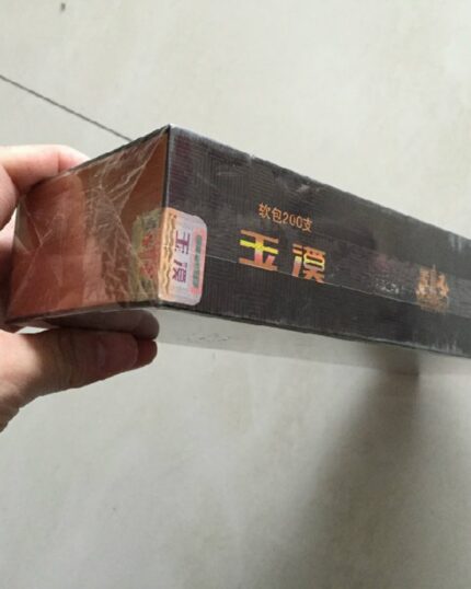 Yuxi Jingjie Mid cigarette packaging, side of a black carton held in one hand