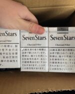 Seven Stars Charcoal cigarette packaging, three white charcoal-filter packs inside an open carton