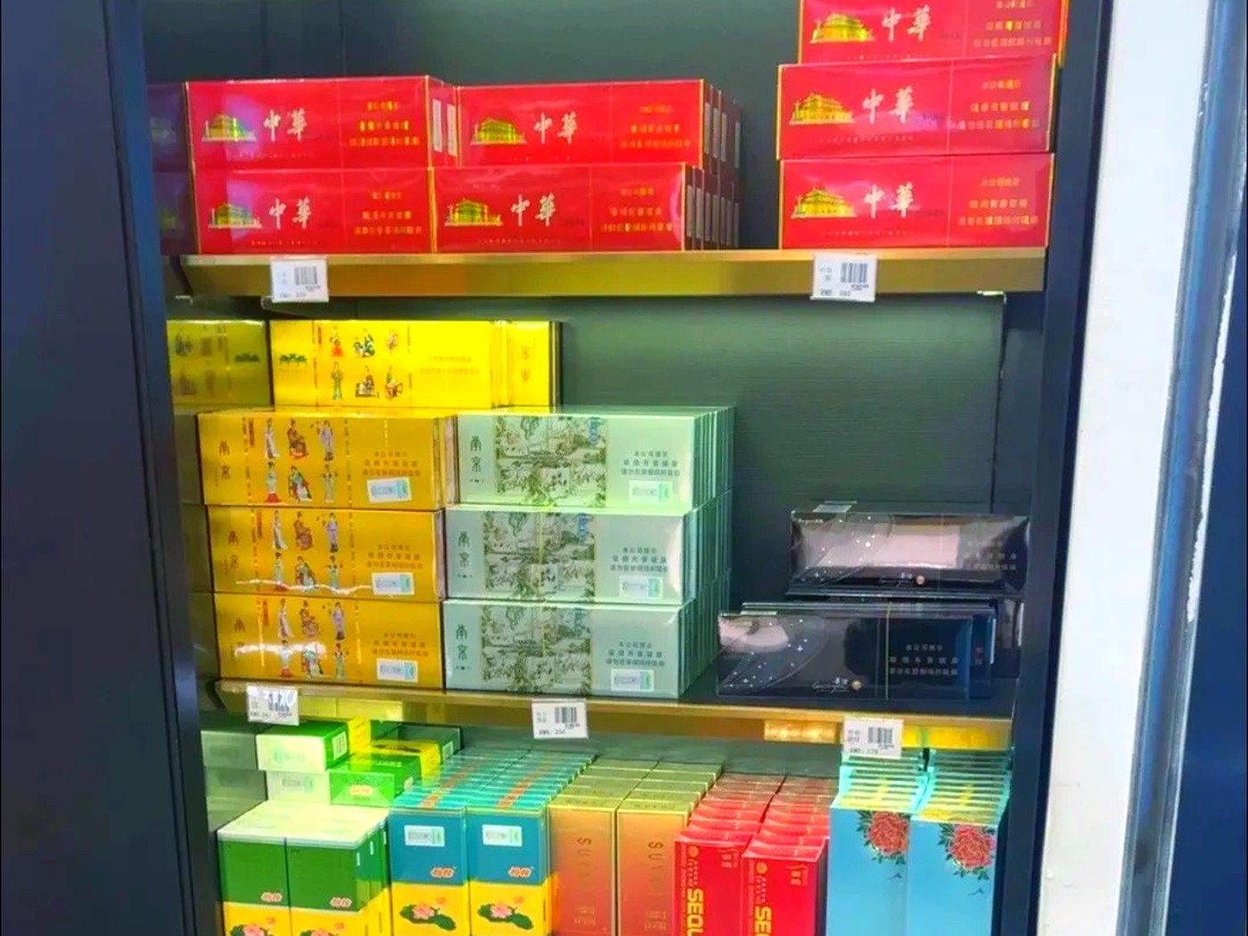 Hands inspecting a sealed carton of authentic cigarettes under good light
