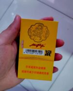 Nanjing 95 Slim cigarette packaging, rear of the yellow pack held in one hand